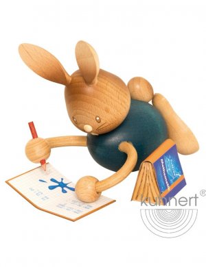Easter bunny Stupsi in homeschooling, lying with exercise book
