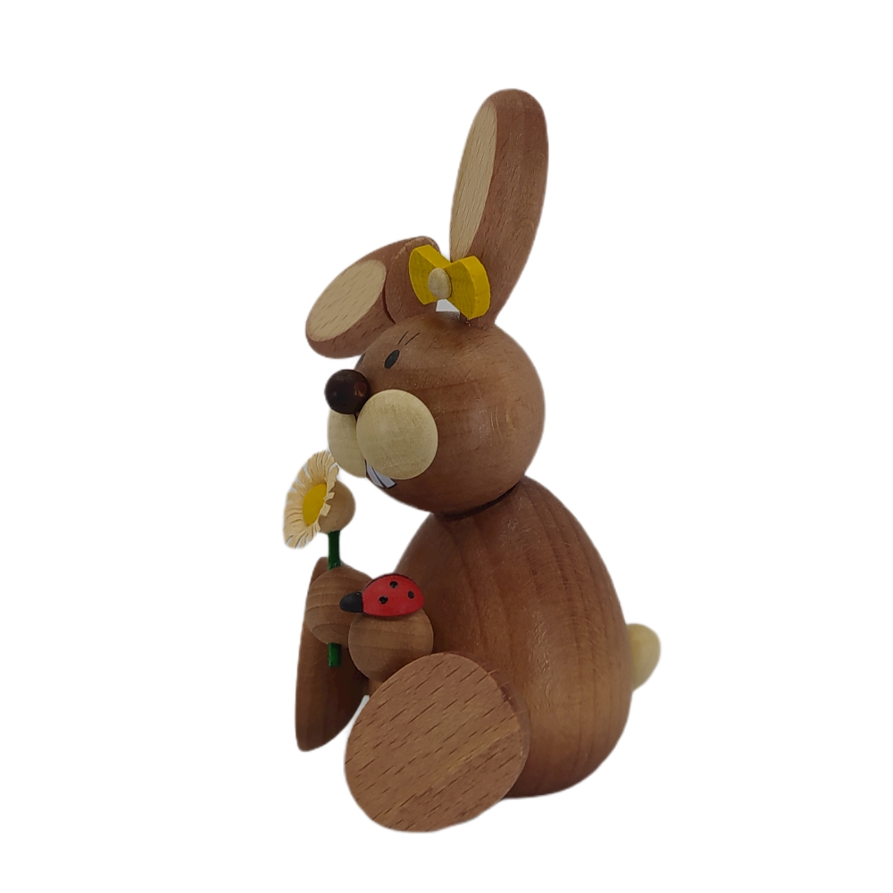 Easter bunny sitting with ladybug and flower